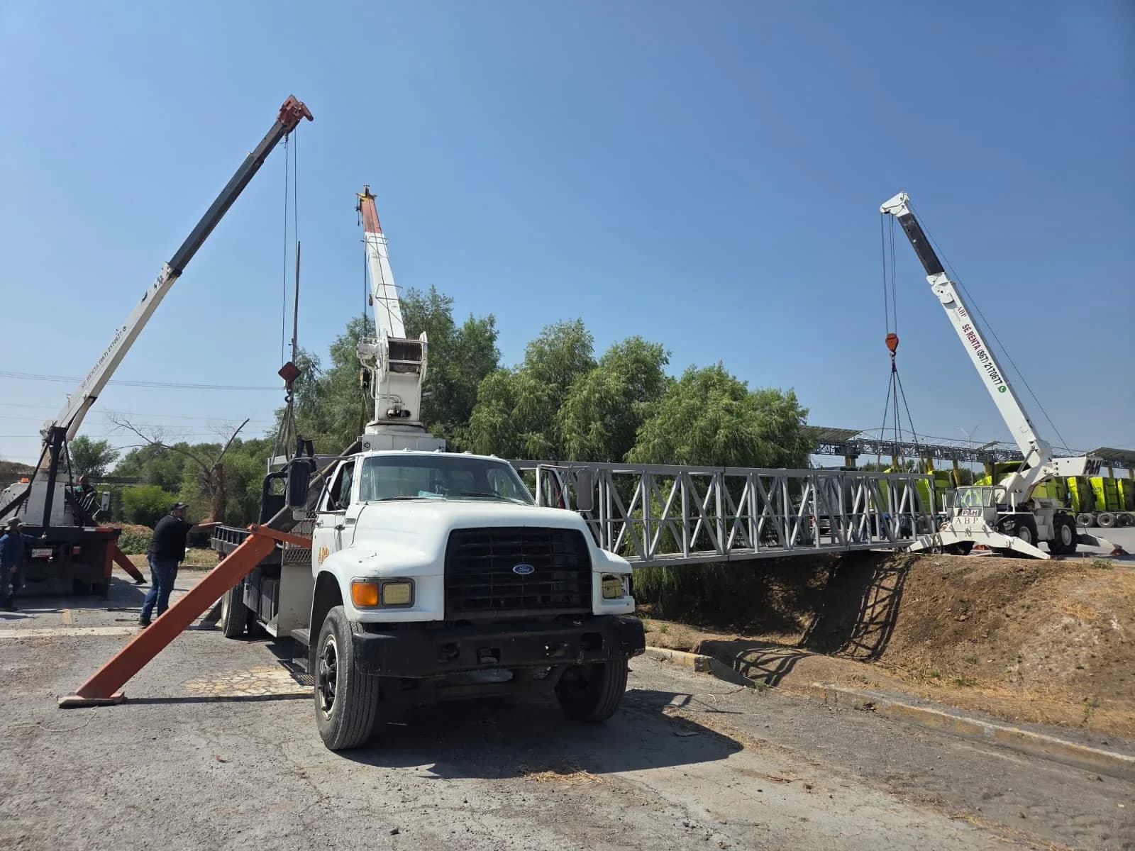 Colocación de un puente peatonal sobre un canal, con maniobra coordinada a tres grúas